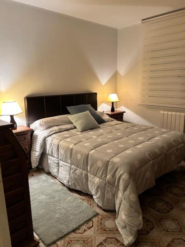 ein Schlafzimmer mit einem großen Bett mit zwei Lampen an Tischen in der Unterkunft La Lama in San Emiliano