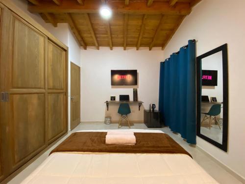 a bedroom with a large bed and a blue curtain at Casa Dorada - Confort a solo una cuadra del Parque in Carmen de Viboral