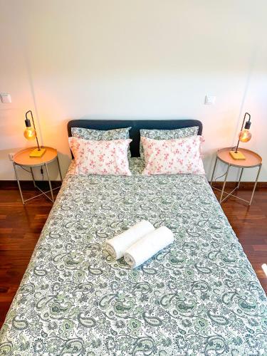 a bed with two towels and two lamps on it at Espinho in São Félix da Marinha