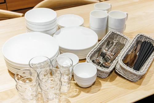 a table with white plates and glasses on it at GRACE VILLA Aso Kurokawa in Minamioguni