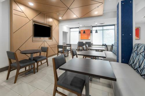 a dining room with tables and chairs and a tv at Holiday Inn Express Salt Lake City South - Midvale by IHG in Midvale