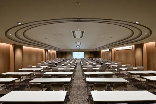 an empty room with desks and chairs in it at Yunogo Onsen HOTEL YUNOMORI BISYUNKAKU in Mimasaka