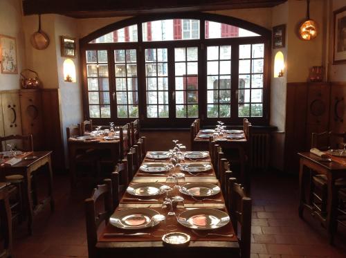 a dining room with a long table with plates on it at Auberge des Seigneurs in Vence