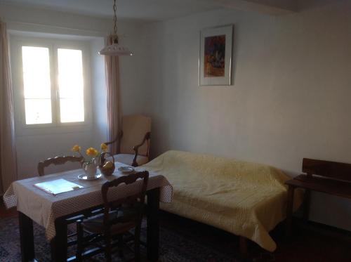 a bedroom with a bed and a table and a window at Auberge des Seigneurs in Vence
