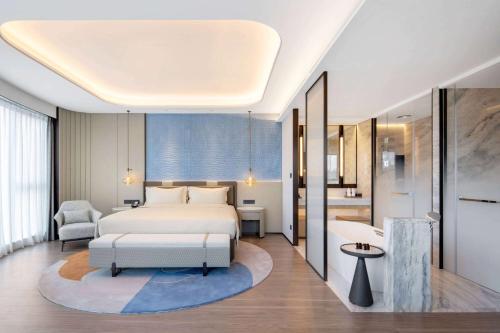 a bedroom with a bed and a bathroom at Wyndham Grand Plaza Royale Lugu Changsha in Changsha