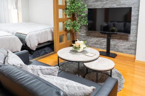 a living room with a couch and a tv at Za086 柏原ビル101 in Tokyo