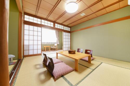 a room with a table and a chair and a table at Hotel Omaruyama in Sakura