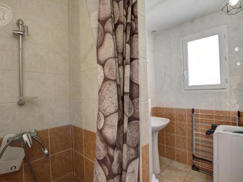 a bathroom with a shower curtain and a sink at Gîte rural avec jardin, parking et WiFi - Saint-Romain-en-Jarez - FR-1-496-295 in Saint-Romain-en-Jarez