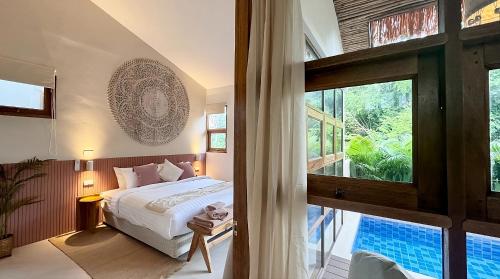 チャウエンノイビーチにあるVilla La Terracotta - Vue Jardin, Villa 18のベッドと大きな窓のある寝室