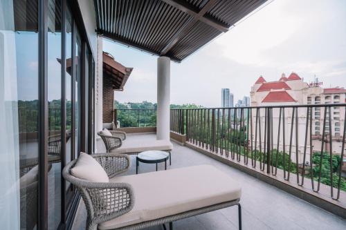 a balcony with chairs and tables on a building at Palm Garden Hotel, Putrajaya, a Tribute Portfolio Hotel in Putrajaya