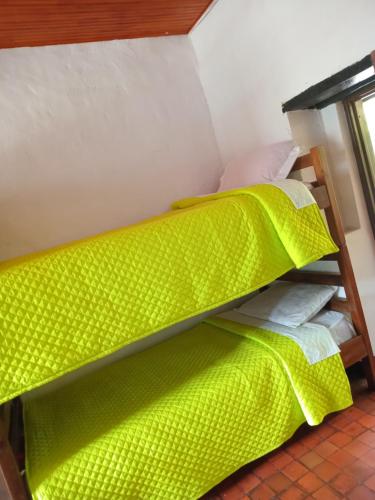 a bunk bed in a room with a green comforter at Hostal Santa Isabel in Iza