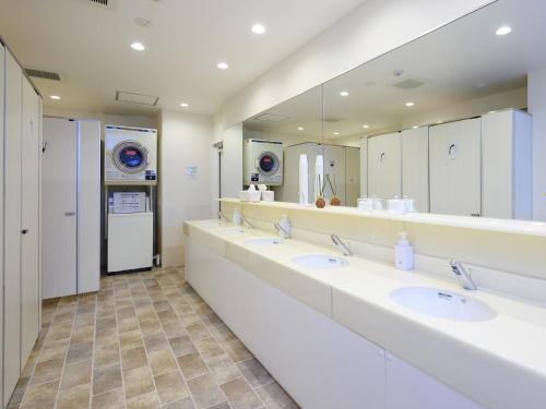 a bathroom with three sinks and a large mirror at HOTEL THE CUBE Naha Kokusai Street in Naha