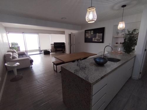 - une cuisine et un salon avec un comptoir et une table dans l'établissement Depa en Punta Hermosa, à Punta Hermosa