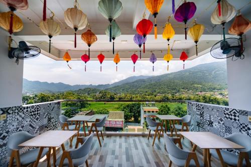 a restaurant with tables and chairs and colorful umbrellas at Ha Giang City Hotel in Ha Giang