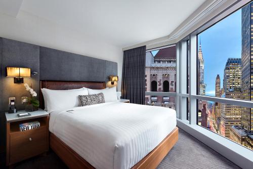 a bedroom with a large bed and a large window at Hotel 48LEX New York in New York