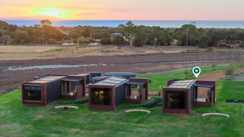 a group of modular homes on a grass field at Samphire Chalet Banksia - A Serene Natural Beauty in Geographe