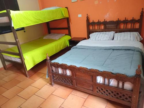 two bunk beds in a room with green sheets at Hostal Santa Isabel in Iza