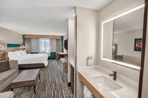 a hotel room with a bed and a bathroom at Holiday Inn Express & Suites Hayward by IHG in Hayward