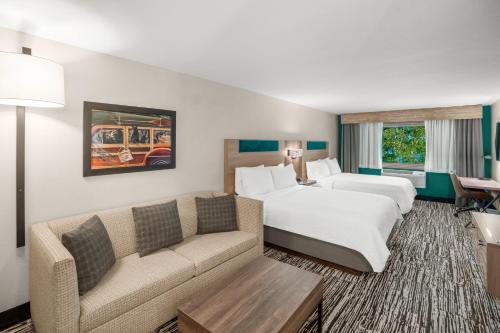 a hotel room with a bed and a couch at Holiday Inn Express & Suites Hayward by IHG in Hayward