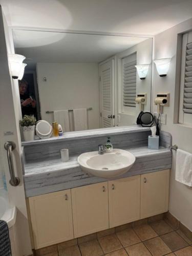 ein Badezimmer mit Waschbecken und Spiegel in der Unterkunft Five o clock somewhere in Golden Beach