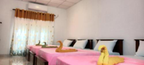 a row of pink beds with toy animals on them at LLT kuweni palace and safari in Horuwila