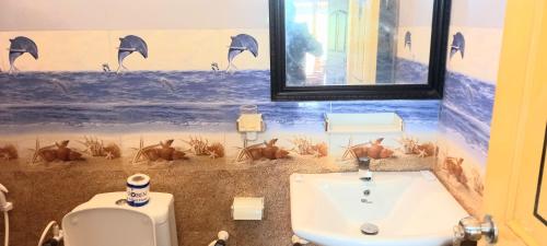 a bathroom with a sink and a toilet and a mirror at LLT kuweni palace and safari in Horuwila