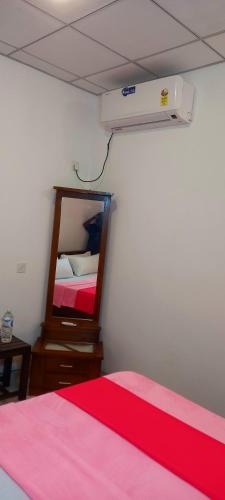 a bedroom with a bed and a dresser and avertisement at LLT kuweni palace and safari in Horuwila