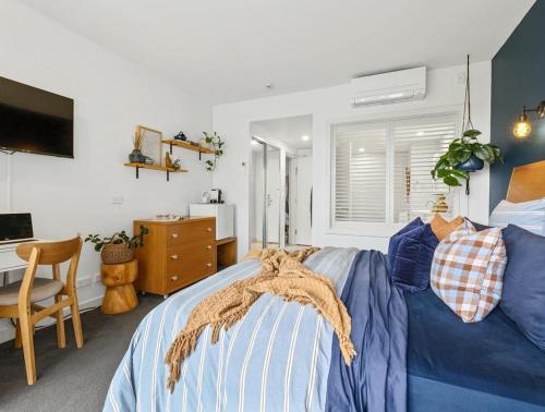 - une chambre avec un lit bleu et un bureau dans l'établissement The Pool Resort Kingscliff - Studio with Garden View (5203) - Holiday Management Co., à Kingscliff