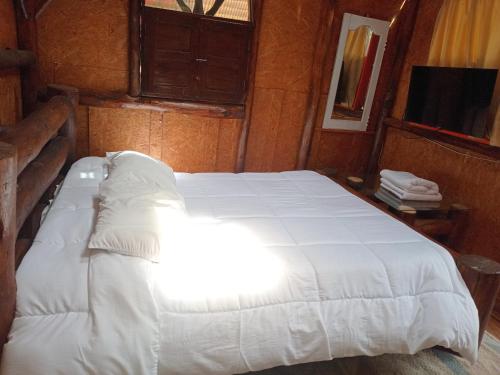 a bedroom with a large white bed in a room at Hostal Santa Isabel in Iza