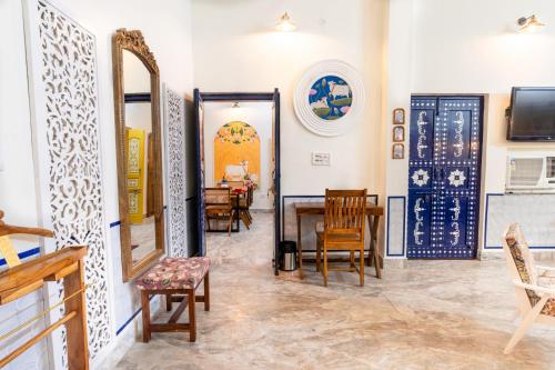 a room with chairs and a table and a mirror at Gopagiri Homestay - Gwalior in Gwalior