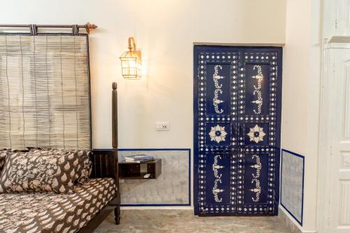 a living room with a blue door and a couch at Gopagiri Homestay - Gwalior in Gwalior
