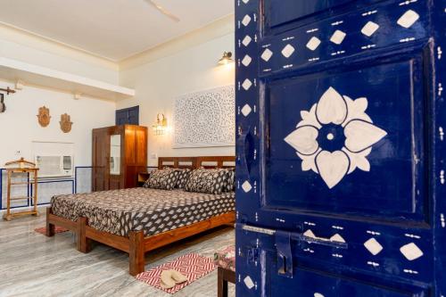 a bedroom with a bed and a blue wall at Gopagiri Homestay - Gwalior in Gwalior