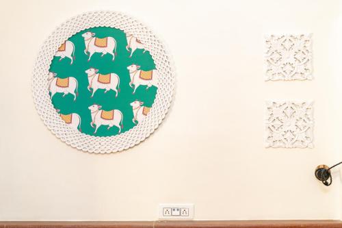 a plate with horses on a wall next to a clock at Gopagiri Homestay - Gwalior in Gwalior