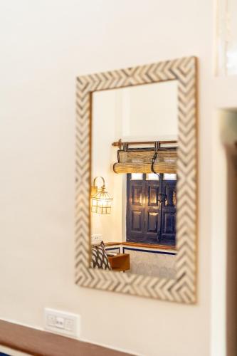 a mirror on a wall reflecting a living room at Gopagiri Homestay - Gwalior in Gwalior