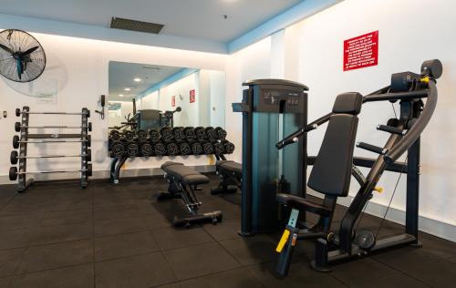 a gym with dumbbells and weights in a room at Rydges Canberra in Canberra