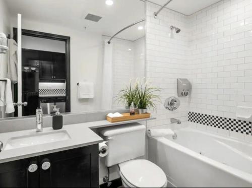 a bathroom with a tub and a toilet and a sink at Ideal Central Village Location! in Whistler