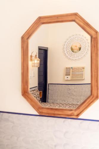a mirror on a wall with a bed in a room at Gopagiri Homestay - Gwalior in Gwalior