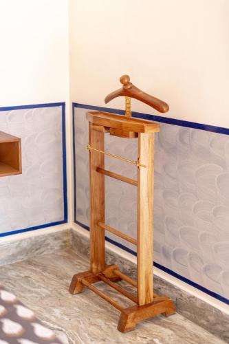 a wooden shelf in the corner of a room at Gopagiri Homestay - Gwalior in Gwalior
