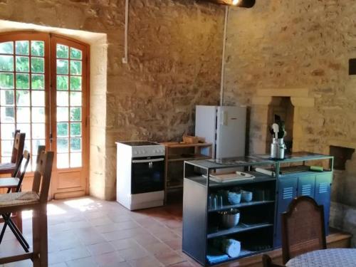 une cuisine avec une cuisinière et un réfrigérateur dans l'établissement Maison campagnarde avec piscine, animaux acceptés, Wi-Fi, parking, cheminée - FR-1-616-424, à Thenon