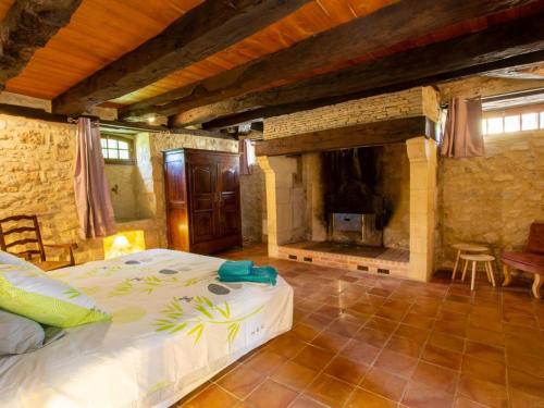 a bedroom with a bed and a fireplace at Maison campagnarde avec piscine, animaux acceptés, Wi-Fi, parking, cheminée - FR-1-616-424 in Thenon