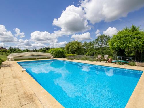 a swimming pool with blue water in a yard at Maison campagnarde avec piscine, animaux acceptés, Wi-Fi, parking, cheminée - FR-1-616-424 in Thenon