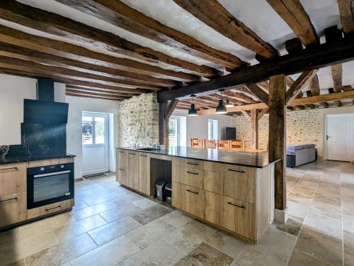 une grande cuisine avec des armoires en bois et une cuisinière dans l'établissement Maison familiale rénovée dans village médiéval - FR-1-591-712, à Levroux