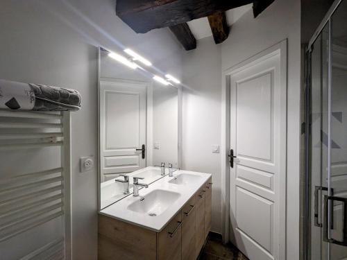 une salle de bain blanche avec un lavabo et un miroir dans l'établissement Maison familiale rénovée dans village médiéval - FR-1-591-712, à Levroux
