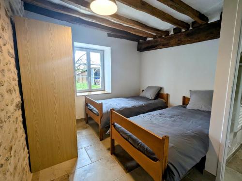 une chambre avec deux lits et une fenêtre dans l'établissement Maison familiale rénovée dans village médiéval - FR-1-591-712, à Levroux