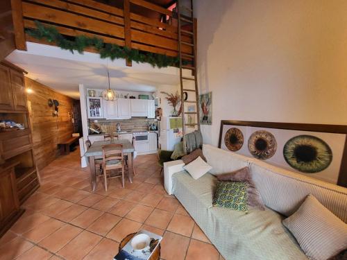 un salon avec un canapé et une cuisine dans l'établissement Duplex 2 chambres centre Montgenèvre avec wifi - FR-1-266-240, à Montgenèvre
