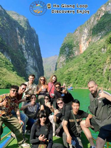 a group of people posing for a picture in front of a mountain at Ha Giang City Hotel in Ha Giang