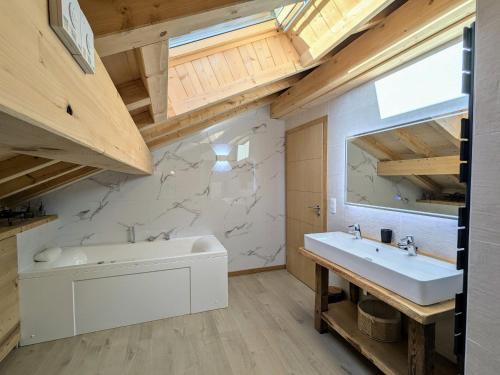 a bathroom with a white tub and a sink at Chalet grand confort avec sauna et balnéo - Proche stations de ski - FR-1-589-762 in Xonrupt-Longemer