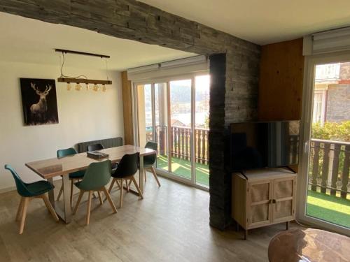 une salle à manger avec une table et une télévision dans l'établissement Gîte spacieux à Gérardmer avec vue sur lac, 3 chambres, Wi-Fi et parking - FR-1-589-761, à Gérardmer