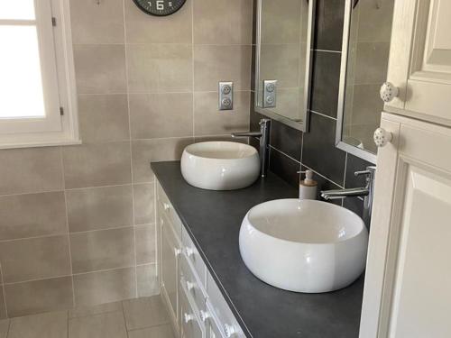 La salle de bains est pourvue de 2 lavabos et d'un miroir sur un comptoir. dans l'établissement Gîte spacieux à Gérardmer avec vue sur lac, 3 chambres, Wi-Fi et parking - FR-1-589-761, à Gérardmer