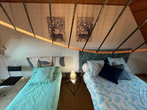 une chambre avec deux lits dans une tente dans l'établissement Maison rénovée à Fouesnant, proche plages, jardin et terrasse - FR-1-481-167, à Fouesnant